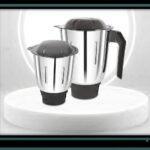 "Modern 2-jar mixer grinder kept on a clean kitchen marble countertop." "Compact mixer grinder with two stainless steel jars placed next to fresh herbs and spices."